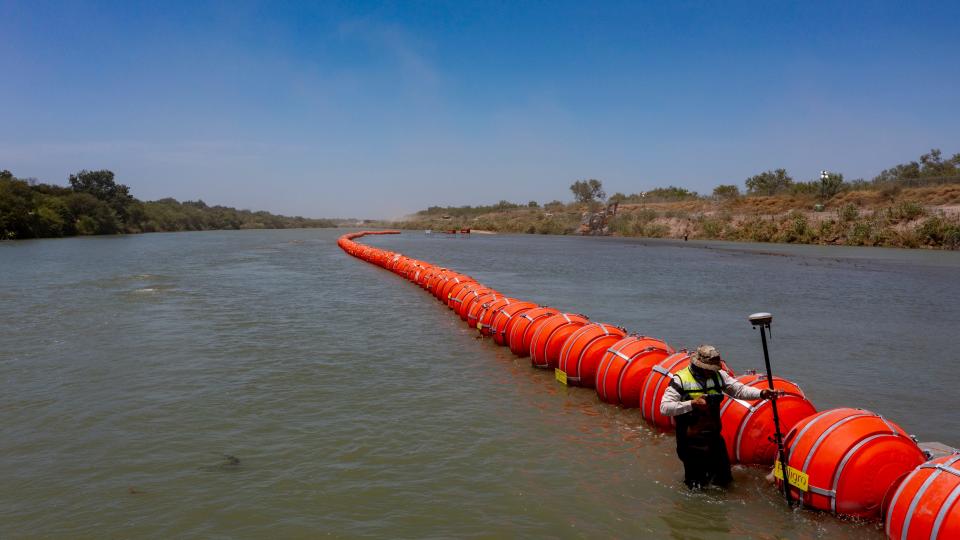 Buoys float on the Rio Grande River in Eagle Pass, Texas on July 20, 2023, as a Mexican engineer with the International Boundary and Water Commission uses GPS determine to see if the buoys are crossing into Mexican territory. The buoys were installed on orders by Texas Governor Greg Abbott as an obstacle to prevent migrants from reaching the north embankment of the Rio Grande on the international boundary between Mexico and the U.S.