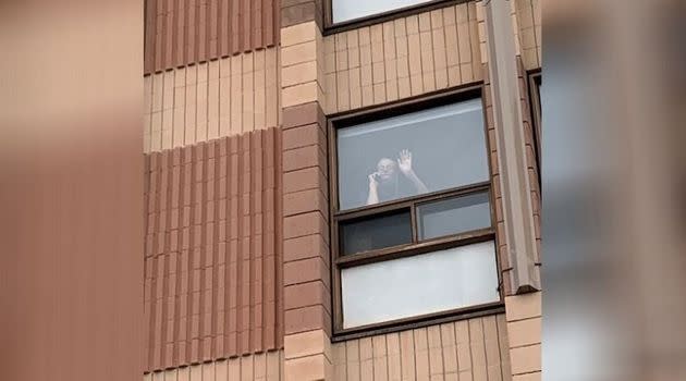 Christine Collins’ brother Peter waves from his room at Carlingview Manor on April 30, 2020.