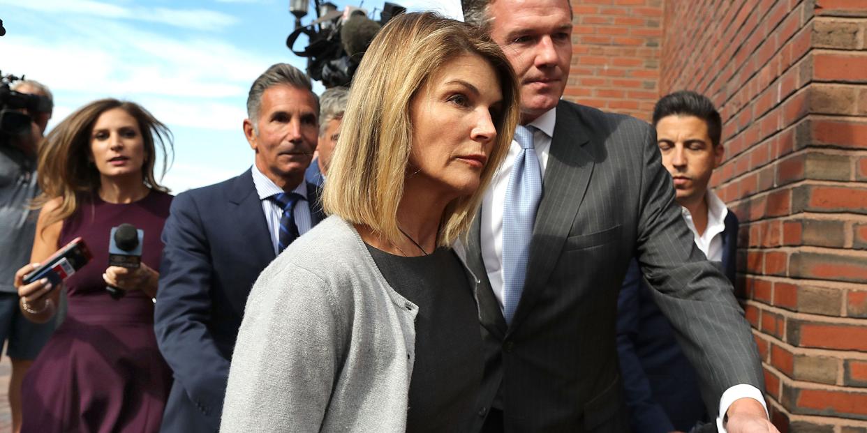 Lori Loughlin and her husband Mossimo Giannulli, behind her at left, leave the John Joseph Moakley United States Courthouse in Boston on Aug. 27, 2019.