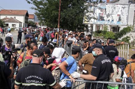 Migrants and refugees wait in line to enter a camp in the town of Presevo, Serbia, August 26, 2015. REUTERS/Agron Beqiri