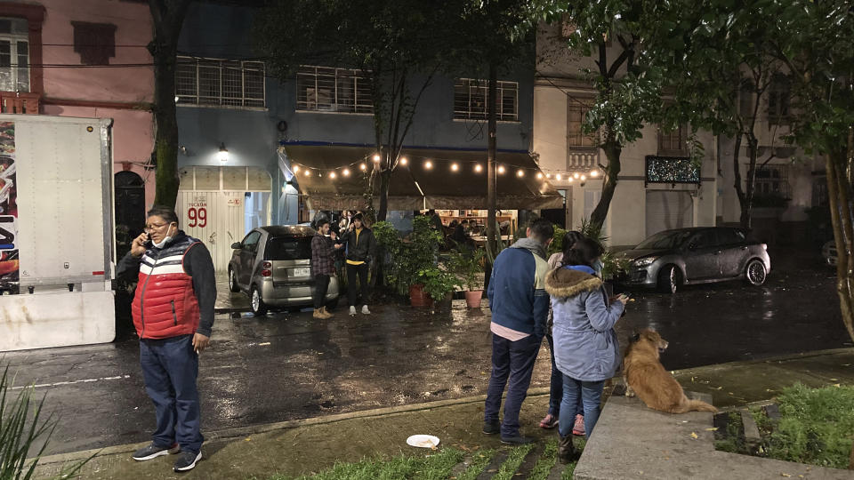 People gather outside on the sidewalk after a strong earthquake was felt, in the Roma neighborhood of Mexico City, Tuesday, Sept. 7, 2021. The quake struck southern Mexico near the resort of Acapulco, causing buildings to rock and sway in Mexico City nearly 200 miles away. (AP Photo/Leslie Mazoch)