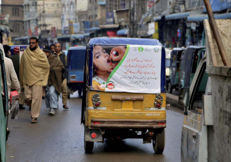 FILE - An auto rickshaw with a poster advertising an oral polio campaign, drives through a market in Peshawar, Pakistan in this 2020 photo. In a surprising twist in the decades-long effort to eradicate the virus, authorities in Jerusalem, New York and London have discovered evidence that polio is spreading there. The source of the virus? The oral vaccine itself. For years, global health officials have used an oral vaccine in an attempt to wipe out polio from its last remaining strongholds in countries including Afghanistan, Pakistan and Nigeria. (AP Photo/Muhammad Sajjad, File)