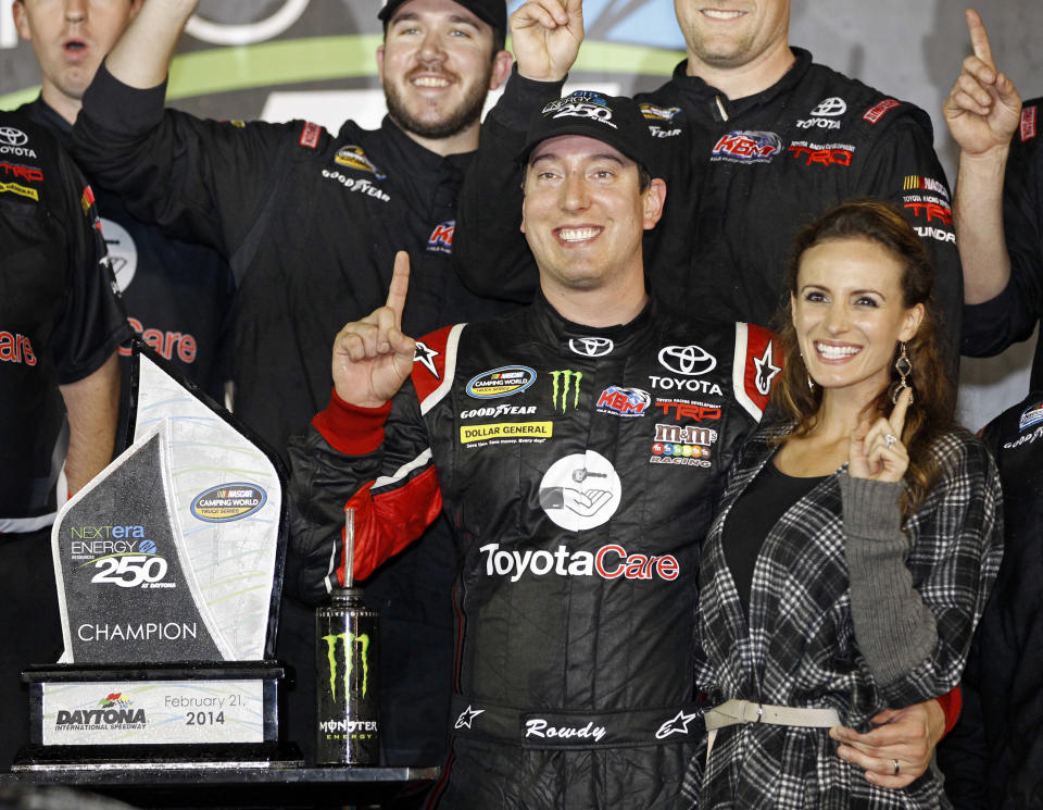 Kyle Busch celebrates in Victory Lane with his wife, Samantha, right, after winning the NASCAR Truck Series auto race at Daytona International Speedway in Daytona Beach, Fla., Friday, Feb. 21, 2014. (AP Photo/Terry Renna)