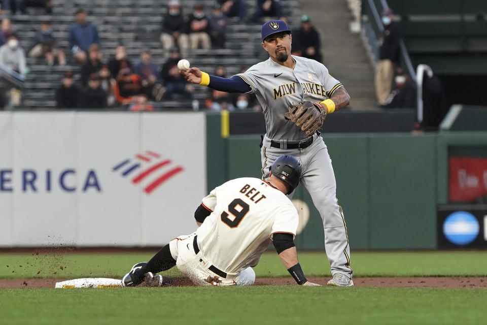 Milwaukee Brewers second baseman Jace Peterson, top, throws to first base after forcing out San Francisco Giants' Brandon Belt (9) at second base on a double play hit into by Buster Posey during the first inning of a baseball game in San Francisco, Wednesday, Sept. 1, 2021. (AP Photo/Jeff Chiu)