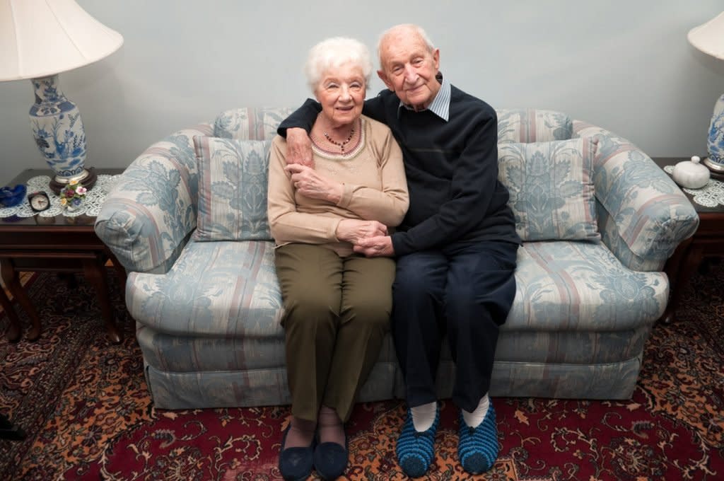 A married couple sit on a couch.