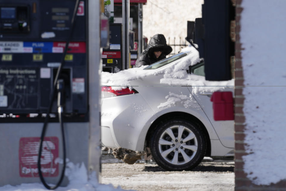 A woman fills up her gas tank at a gas station in Arlington Heights, Ill., Sunday, Jan. 14, 2024. A wind chill warning is in effect as dangerous cold conditions continue in the Chicago area. (AP Photo/Nam Y. Huh)