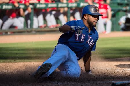 Oct 4, 2015; Arlington, TX, USA; Texas Rangers center fielder Delino DeShields (7) slides into home during the seventh inning against the Los Angeles Angels at Globe Life Park in Arlington. The Rangers won 9-2 and clinch the American League West division. Mandatory Credit: Jerome Miron-USA TODAY Sports