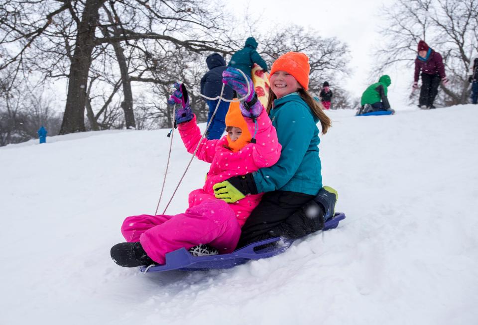 Aarianna Hutchins, 9, right, rides on a plastic sled with her friend Jessie Becker, 8, on Tuesday, Jan. 29, 2019 on the sledding hill outside Palmer Park Recreation Center. Tuesday was the sixth snow day of the year for many local school districts.