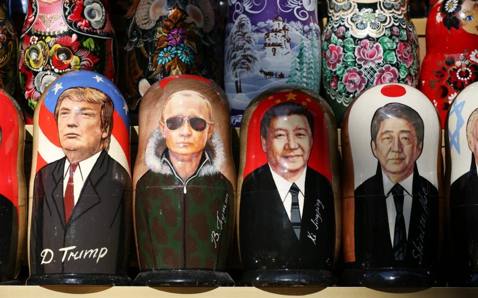 President Trump - here on a matryoshka doll in St Petersburg with other global leaders - wanted to use aid to counter China's growing influence  - Bloomberg