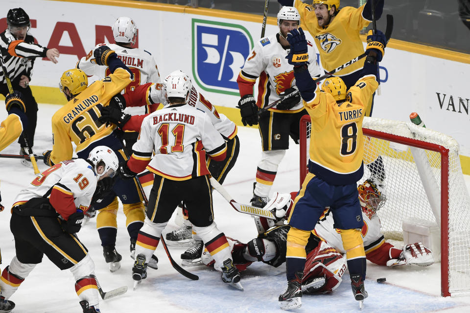 Nashville Predators center Mikael Granlund (64), of Finland, scores against Calgary Flames goaltender David Rittich (33), of the Czech Republic, to tie an NHL hockey game in the third period Thursday, Feb. 27, 2020, in Nashville, Tenn. (AP Photo/Mark Zaleski)