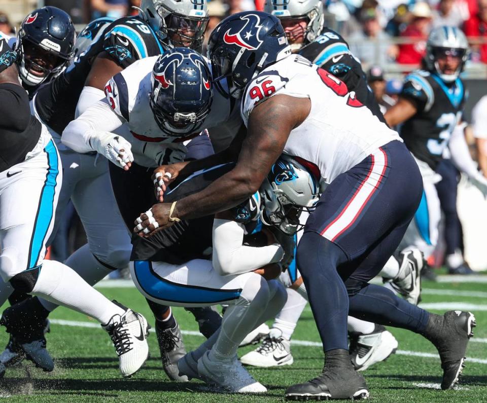 Carolina Panthers quarterback Bryce Young, second from right, hunches down as he is tackled by Houston Texans defensive tackle Maliek Collins during the game at Bank of America Stadium on Sunday, October 29, 2023. Melissa Melvin-Rodriguez/mrodriguez@charlotteobserver.com