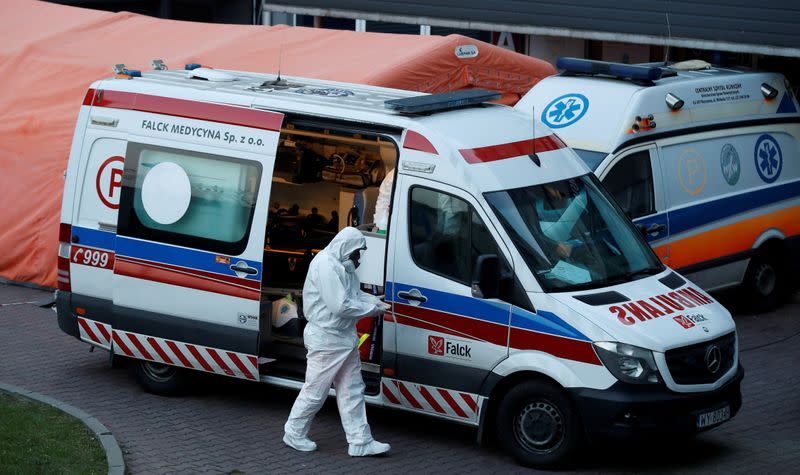 FILE PHOTO: A paramedic walks near an ambulance amid the coronavirus disease (COVID-19) outbreak, in front of a hospital in Warsaw