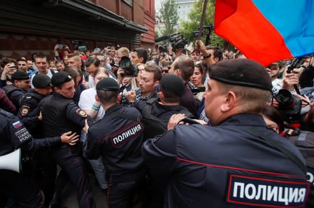 Police officers block protesters at a rally in Moscow