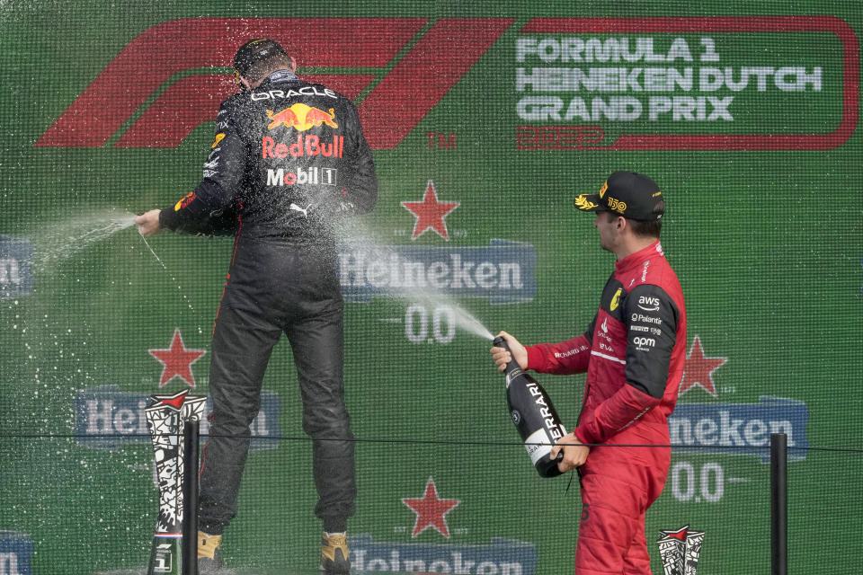 Third placed Ferrari driver Charles Leclerc of Monaco, right, sprays sparkling wine on race winner Red Bull driver Max Verstappen of the Netherlands on the podium of the Formula One Dutch Grand Prix auto race, at the Zandvoort racetrack, in Zandvoort, Netherlands, Sunday, Sept. 4, 2022. (AP Photo/Peter Dejong)