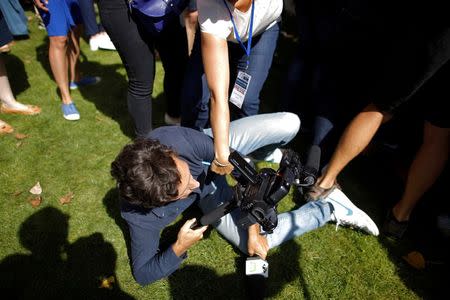 A journalist falls during a stampede as French presidential hopeful Alain Juppe arrives at the Les Republicains (LR) political party summer camp in La Baule, France, September 3, 2016. REUTERS/Stephane Mahe