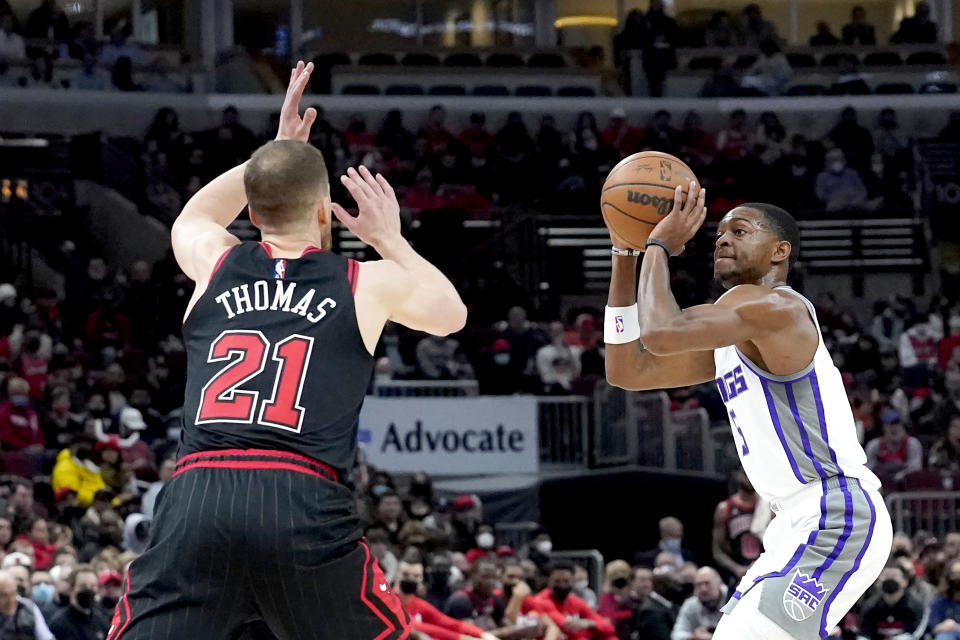 Sacramento Kings' De'Aaron Fox, right, shoots as Chicago Bulls' Matt Thomas defends during the first half of an NBA basketball game Wednesday, Feb. 16, 2022, in Chicago. (AP Photo/Charles Rex Arbogast)