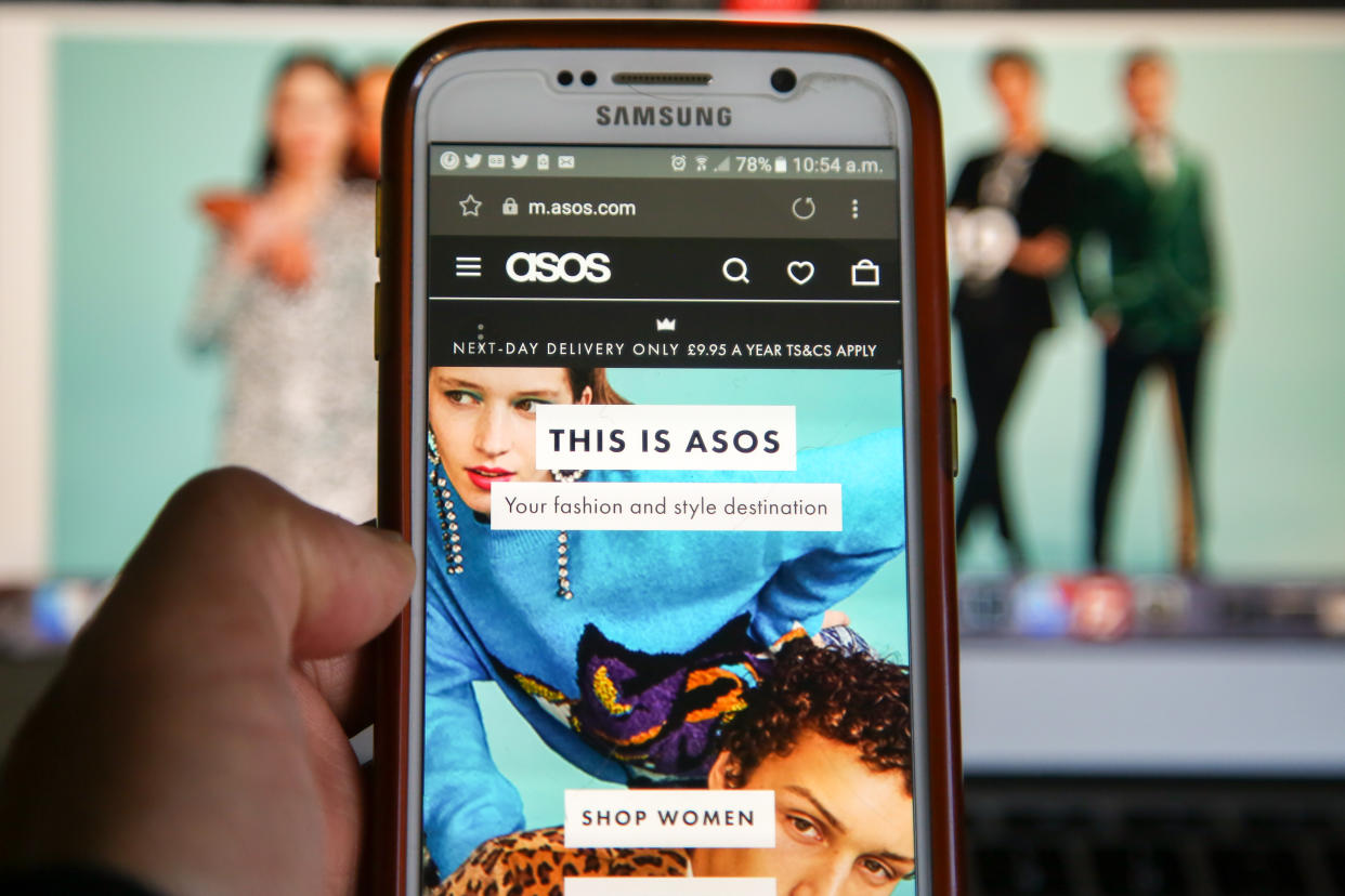 LONDON, UNITED KINGDOM - 2018/12/17:  In this photo illustration, a woman is seen shopping on ASOS the online fashion store on a mobile phone. Shares in Asos tumbled nearly 40 per cent on Monday morning after the online fashion retailer warned of weak profits this financial year after unprecedented discounting hit its trading in November. (Photo Illustration by Dinendra Haria/SOPA Images/LightRocket via Getty Images)