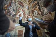 Vatican Museums Scientific Curator Guido Cornini points at the feminine figure, left, known as 'Allegory of Justice' as he speaks to reporters in the Constantine Hall at the Vatican Museums, Wednesday, May 3, 2020.The Vatican Museums announced last month that after restorations they have determined that two of the female figures in the Hall of Constantine were painted in oil by Raphael himself and not by his workshop. (AP Photo/Domenico Stinellis)