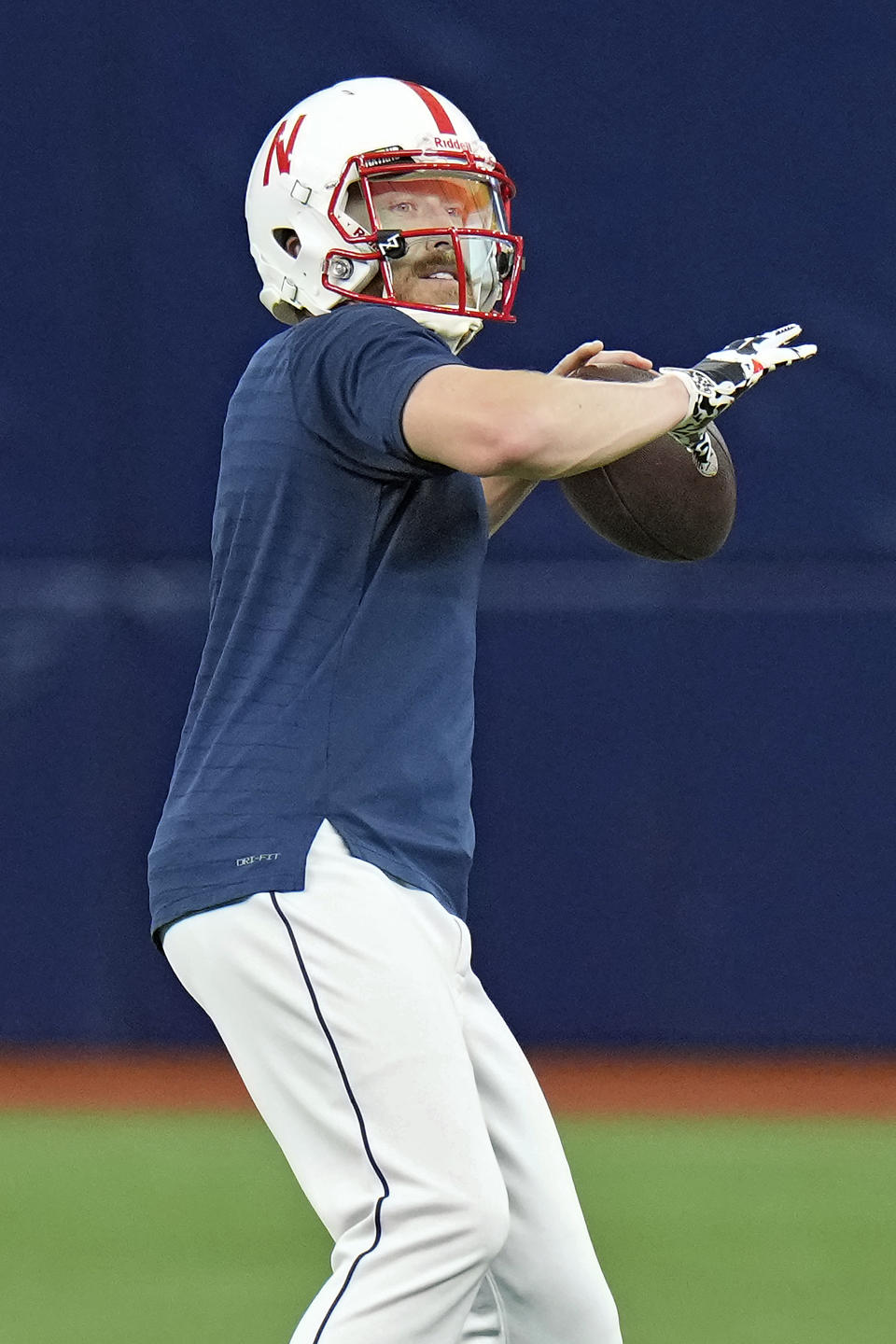 Tampa Bay Rays relief pitcher Jake Diekman dons a University of Nebraska football helmet as he throws the ball while warming up before a baseball game against the Los Angeles Angels Wednesday, Sept. 20, 2023, in St. Petersburg, Fla. Diekman was born in Wymore, Nebraska. (AP Photo/Chris O'Meara)