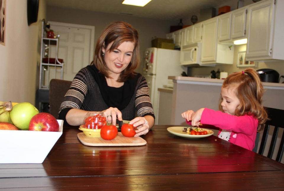 This Jan. 21, 2014 photo released by MediaSource shows Shannon McCormick, left, cutting up a tomato for her 4 year old daughter Sophie Chapman at their home in Gahanna, Ohio. Although not fond of tomatoes, McCormick keeps that fact from her daughter, who loves them. (AP Photo/MediaSource, Robert Leitch)