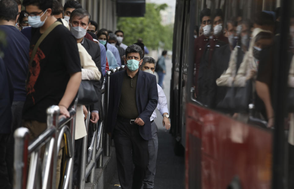 Commuters leave a bus stop in downtown Tehran, Iran, Tuesday, May 11, 2021. (AP Photo/Vahid Salemi)