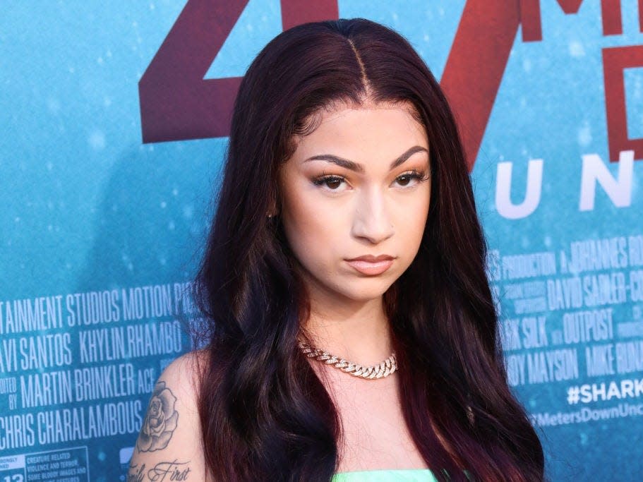 Bhad Bhabie posing for a photo while standing in front of a large poster for the film "47 Meters Down."