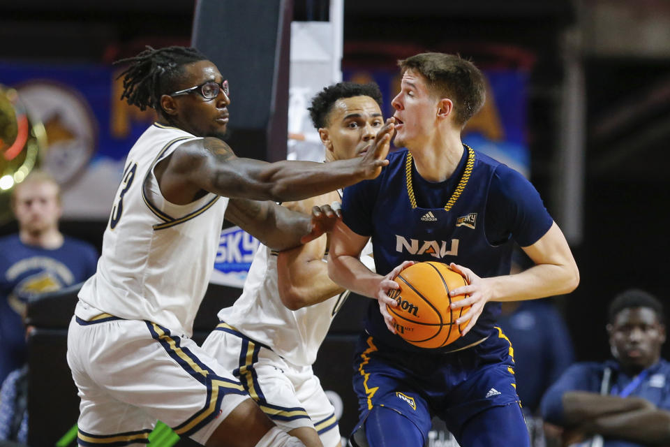 Northern Arizona forward Nik Mains (20) takes a hand from Montana State forward Jubrile Belo (13) to the face under the basket in the first half of an NCAA college basketball game for the championship of the Big Sky men's tournament in Boise, Idaho, Wednesday, March 8, 2023. (AP Photo/Steve Conner)