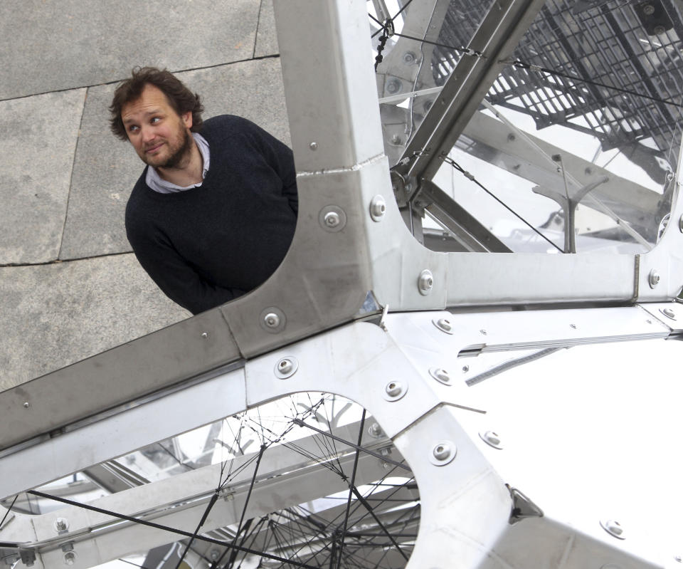 Artist Tomas Saraceno, from Argentina, is reflected in his structure called "Cloud City" during a media preview on the rooftop of the Metropolitan Museum of Art in New York, Monday, May 14, 2012. Sarceno says he wants his work "Cloud City" to provoke the feeling of being in a cloud floating in the middle of several realities. (AP Photo/Seth Wenig)