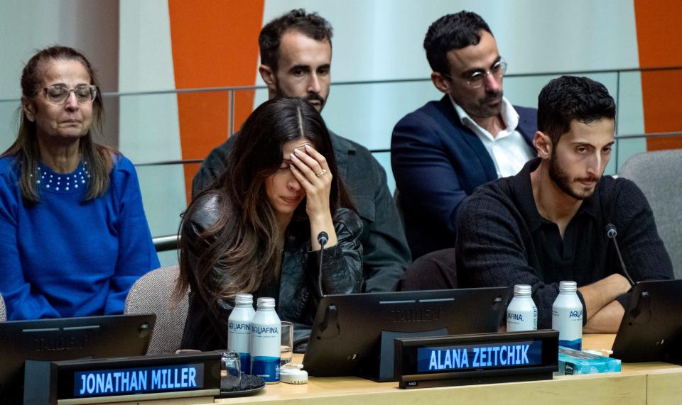 Israeli American family members Rachel Zeitchik, left, Alana Zeitchik, center, and Liam Zeitchik, far right, along with other family members, come together to talk about their loved ones kidnapped by Hamas, members of the Cunio/Alony family.