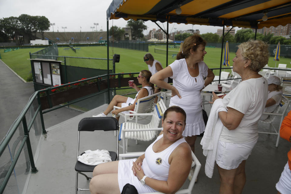 In this Tuesday, July 2, 2013 photo, tennis players relax after matches at the West Side Tennis Club in the Queens section of New York. The Beatles. The Rolling Stones. Frank Sinatra. Jimi Hendrix. Bob Dylan. They’ve all held court at the more than century-old West Side Tennis Club in Queens’ Forest Hills neighborhood - for six decades the site of the U.S. Open Tennis Championships. Plans are now in the works for the grassy lawn to come alive again with the sound of music, starting with a concert featuring the British band Mumford & Sons, to be followed by a lineup of world-class musicians. (AP Photo/Seth Wenig)