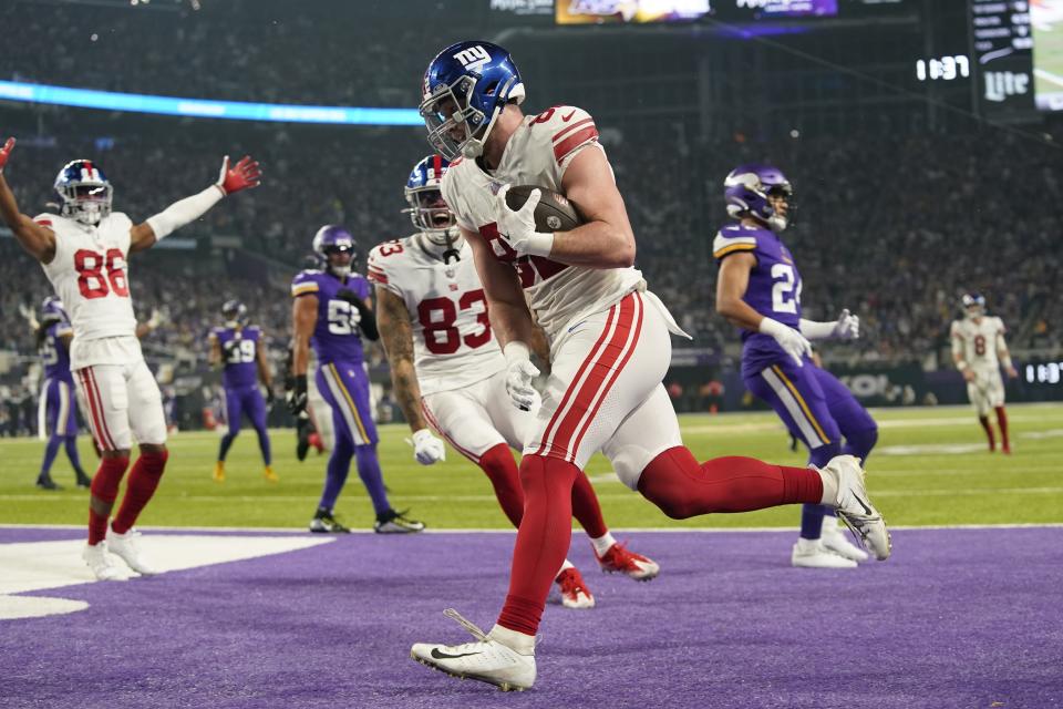 New York Giants' Daniel Bellinger catches a topuchdown pass during the second half of an NFL wild card football game against the Minnesota Vikings Sunday, Jan. 15, 2023, in Minneapolis. (AP Photo/Abbie Parr)