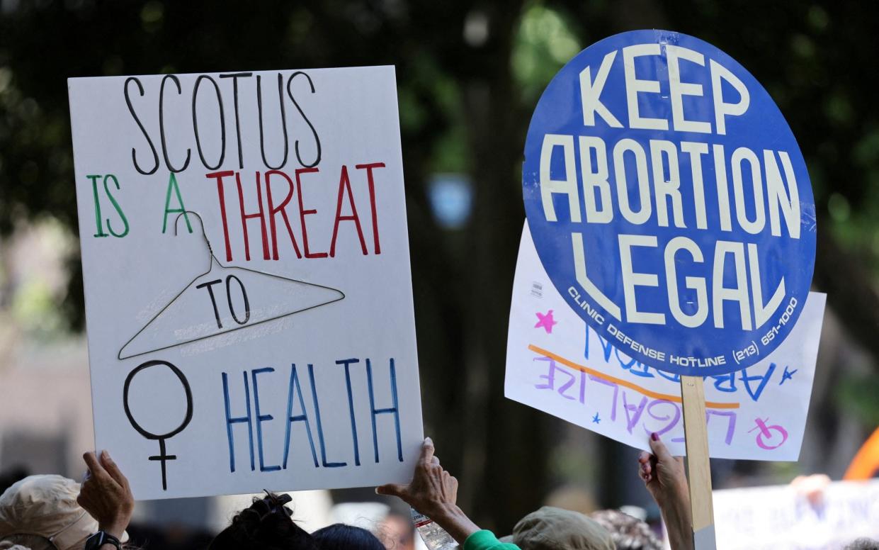 Placards are pictured during a 'Walk-Out for Women' rally on the second anniversary of the U.S. Supreme Court overturning Roe v. Wade