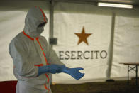 A medical staffer gets ready to perform swabs to test for coronavirus, in the Military barracks of Cecchignola in Rome, Tuesday, Oct. 27, 2020. As Italy faces a new wave of COVID-19 infections, the Italian military is helping healthcare services in the effort to contain infection. Defense minister Lorenzo Guerini has signed an agreement with the Ministry of Health Ministery to provide temporary drive-through structures in to perform nose and throat swabs to increase the daily Covid-19 testing capacity of the country. (AP Photo/Andrew Medichini)