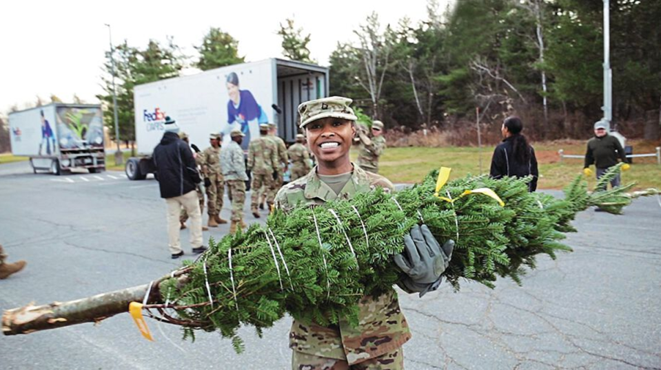 Soldier smiling while holding tree