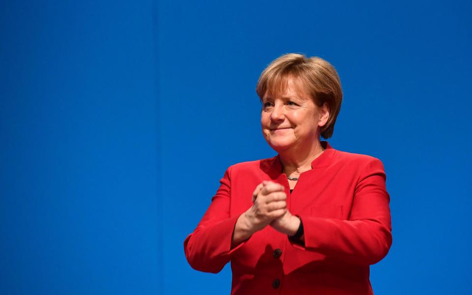 Angela Merkel gestures after addressing delegates during her conservative Christian Democratic Union (CDU) party's congress - Credit: Tobias Schwarz