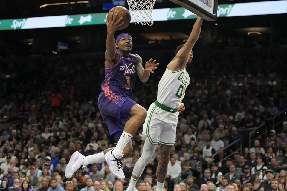 Phoenix Suns guard Bradley Beal (3) drives by Boston Celtics forward Jayson Tatum (0) during the second half of an NBA basketball game, Saturday, March 9, 2024, in Phoenix. (AP Photo/Rick Scuteri)