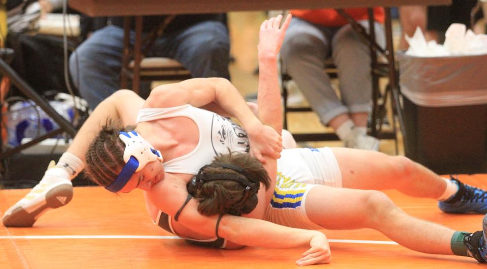 Maysville junior Anthony Humphrey attempts to pin Utica sophomore Nick Drumm in a 138-pound match during the Robin Drumm Invitational at Heath High School on Saturday, Jan. 21, 2023. Humphrey won the match to place third.