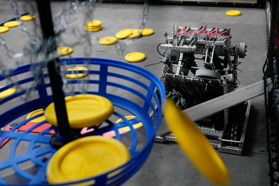 A yellow disc fired from the robot from team Practice Safe Vex narrowly misses the basket during a practice Thursday at Seaman High School.