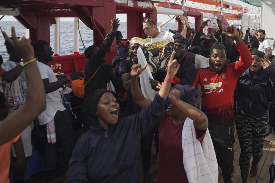 Migrants lift up Basile Fischer, SOS Mediterranee's deputy search and rescue coordinator, during a celebration aboard the Ocean Viking in the Mediterranean Sea, Monday, Sept. 23, 2019. Italy has granted the humanitarian ship permission to sail to the port of Messina in Italy to disembark 182 migrants rescued north of Libya. (AP Photo/Renata Brito)