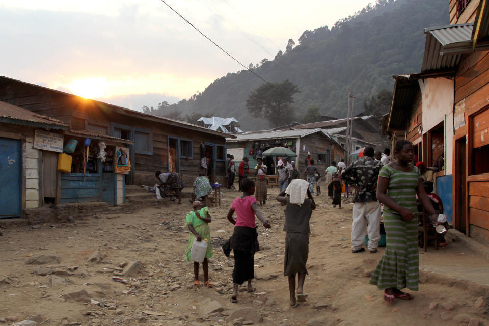 In this photo taken Aug. 16, 2012, people walk down a street in the town of Nyabibwe, eastern Congo, a once bustling outpost fueled by artisanal cassiterite mining. Gold is now the primary source of income for armed groups in eastern Congo, and is ending up in jewelry stores across the world, according to a report published Thursday, Oct. 25, 2012, by the Enough Project. Following American legislation requiring companies to track the origin of the minerals they use, armed groups have been unable to profit from the exploitation of tin (made primarily from cassiterite), tungsten, tantalum, and cassiterite, and have turned instead to gold, which is easier to smuggle across borders. Gold miners, like cassiterite miners, work in extreme conditions, with crude equipment such as pick-axes and shovels. (AP Photo/Marc Hofer)