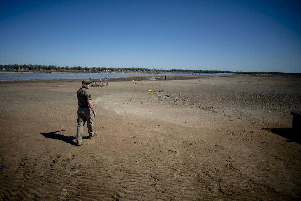 Sanford resident Clint Clark, 44, walks out into what was once the bottom of Wixom Lake after water washed out due to the failure of the Edenville Dam on Wednesday, May 20, 2020 in Edenville Township north of Midland, Mich. (Jake May/The Flint Journal, MLive.com via AP)