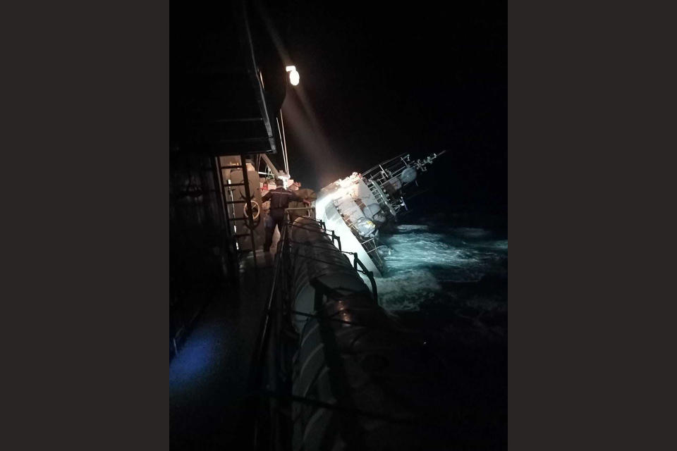 In this photo provided by the Royal Thai Navy, the HTMS Sukhothai corvette leans on its side off the coast of Prachuap Khiri Khan province, Thailand on Sunday, Dec. 18, 2022. The Thai navy ship sunk in the Gulf of Thailand and ships and helicopters were working Monday to rescue sailors from the water. (Royal Thai Navy via AP)