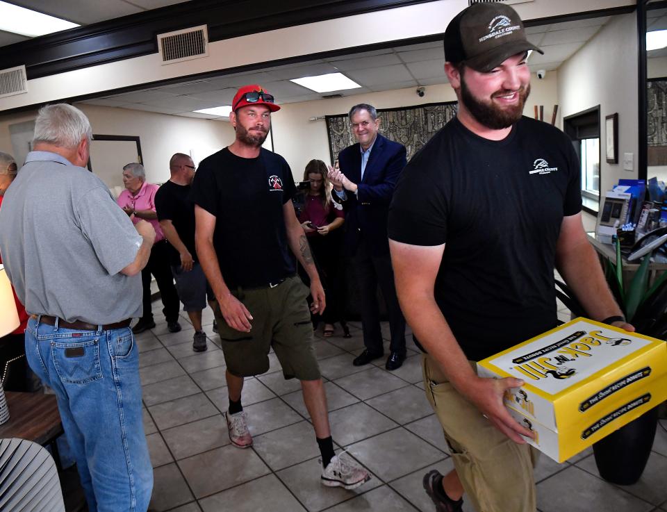 Air crews are applauded by local leaders as they exit their daily briefing Wednesday at Abilene Aero. The crews from the Texas A&M Forest Service air tanker base at Abilene Regional Airport, in coordination with local fire departments, were credited with keeping the weekend's Hill Top Fire south of Abilene from reaching homes in the area.