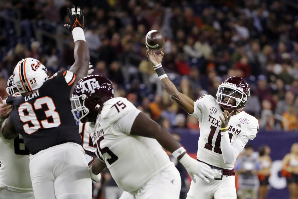 Texas A&M quarterback Marcel Reed, right, passes the ball over Oklahoma State nose tackle Collin Clay (93) and Texas A&M offensive lineman Kam Dewberry (75) during the first half of the Texas Bowl NCAA college football game Wednesday, Dec. 27, 2023, in Houston. (AP Photo/Michael Wyke)