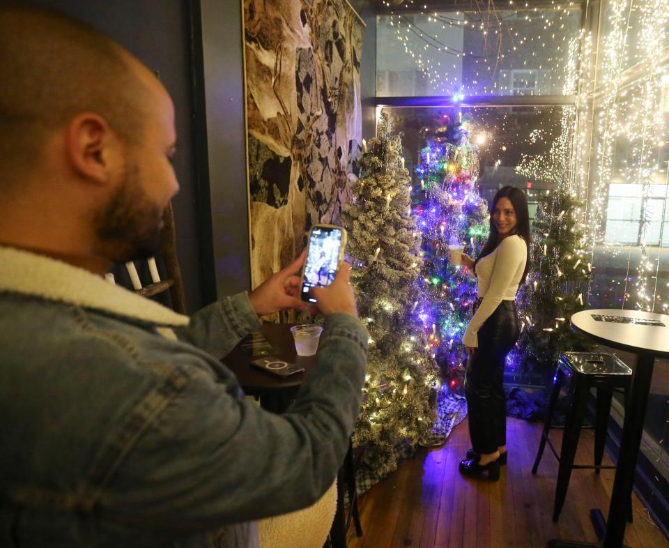 Weldon Maldonado of Wilmington snaps a photo of Carolyn Carpino of Audubon, NJ, at Blitzen, the Christmas-themed "pop-up" bar at 220 W. Ninth Street, open Wednesdays-Saturdays through Dec. 23.