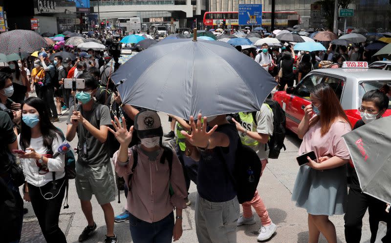 People wearing face masks take part in a protest against the second reading of a controversial national anthem law in Hong Kong