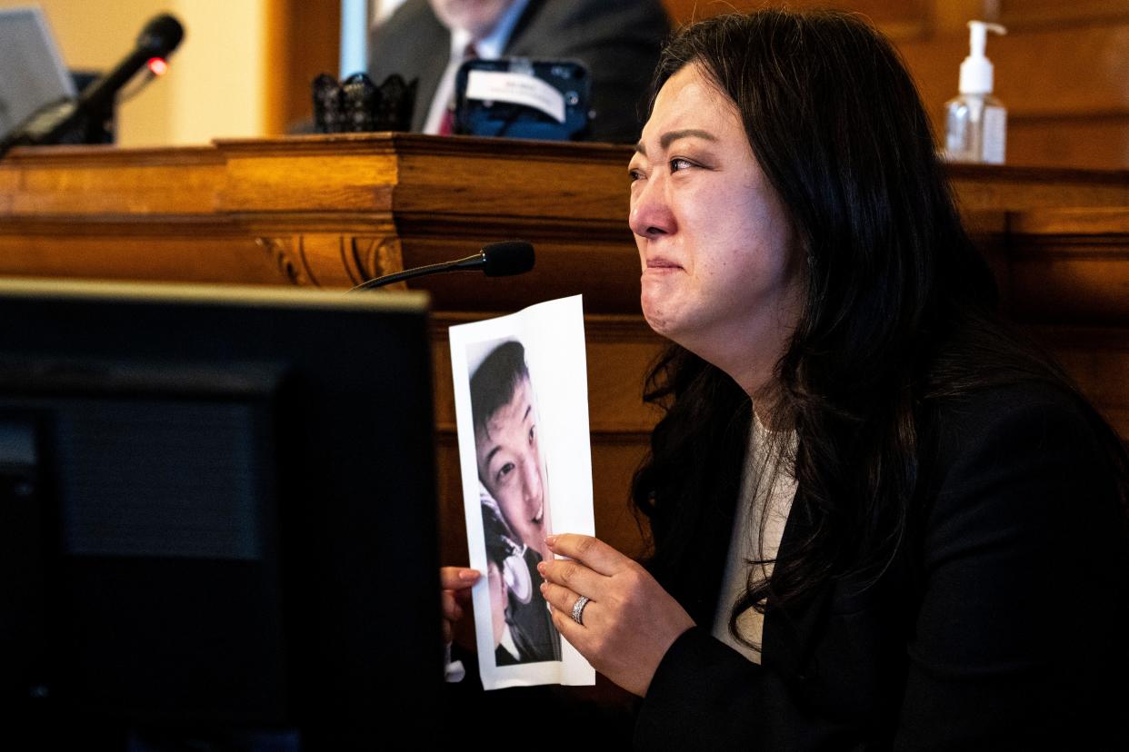 Soojin Nam, Sung Woo Nam's sister, holds up a photo of her brother as she reads her victim impact statement during a sentencing hearing for Gowun Park at the Dallas County Courthouse on Thursday.