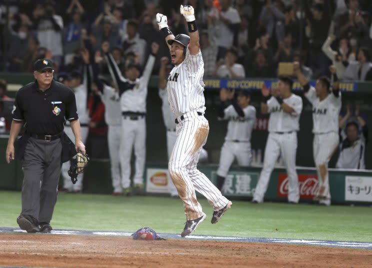 Japan's Nobuhiro Matsuda celebrates at home after scoring on Seiichi Uchikawa's sacrifice fly against Cuba in the eighth inning of their second round game at the World Baseball Classic at Tokyo Dome in Tokyo, Tuesday, March 14, 2017.(AP Photo/Toru Takahashi)