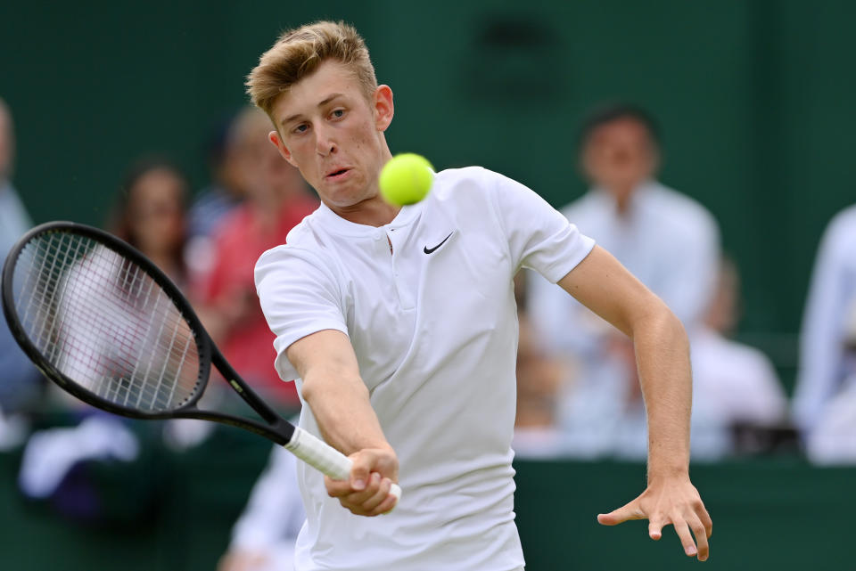 Phoenix Weir of Great Britain plays a forehand against Alexander Blockx of Belgium during their Boys' Singles match at Wimbledon