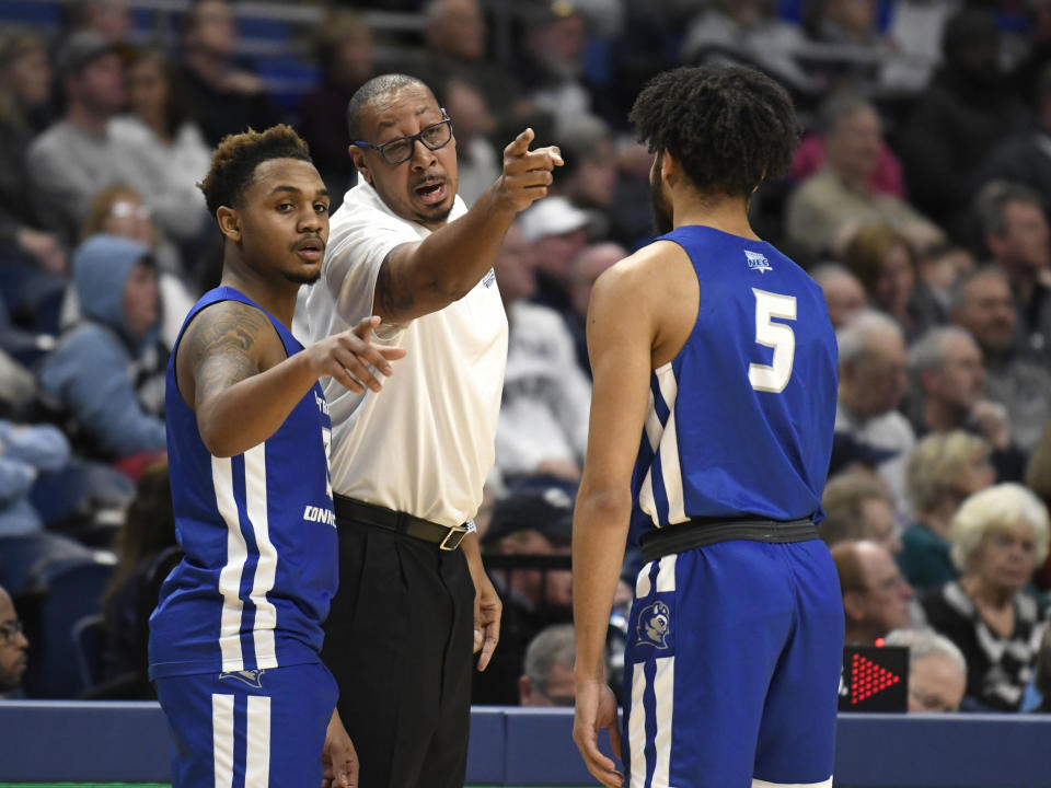 Central Connecticut State coach Donyell Marshall, center, talks with his players Ian Krishnan (3), left, and Xavier Wilson (5) during the first half of an NCAA college basketball game against Penn State, Friday, Dec. 20, 2019, in State College, Pa. (AP Photo/John Beale)